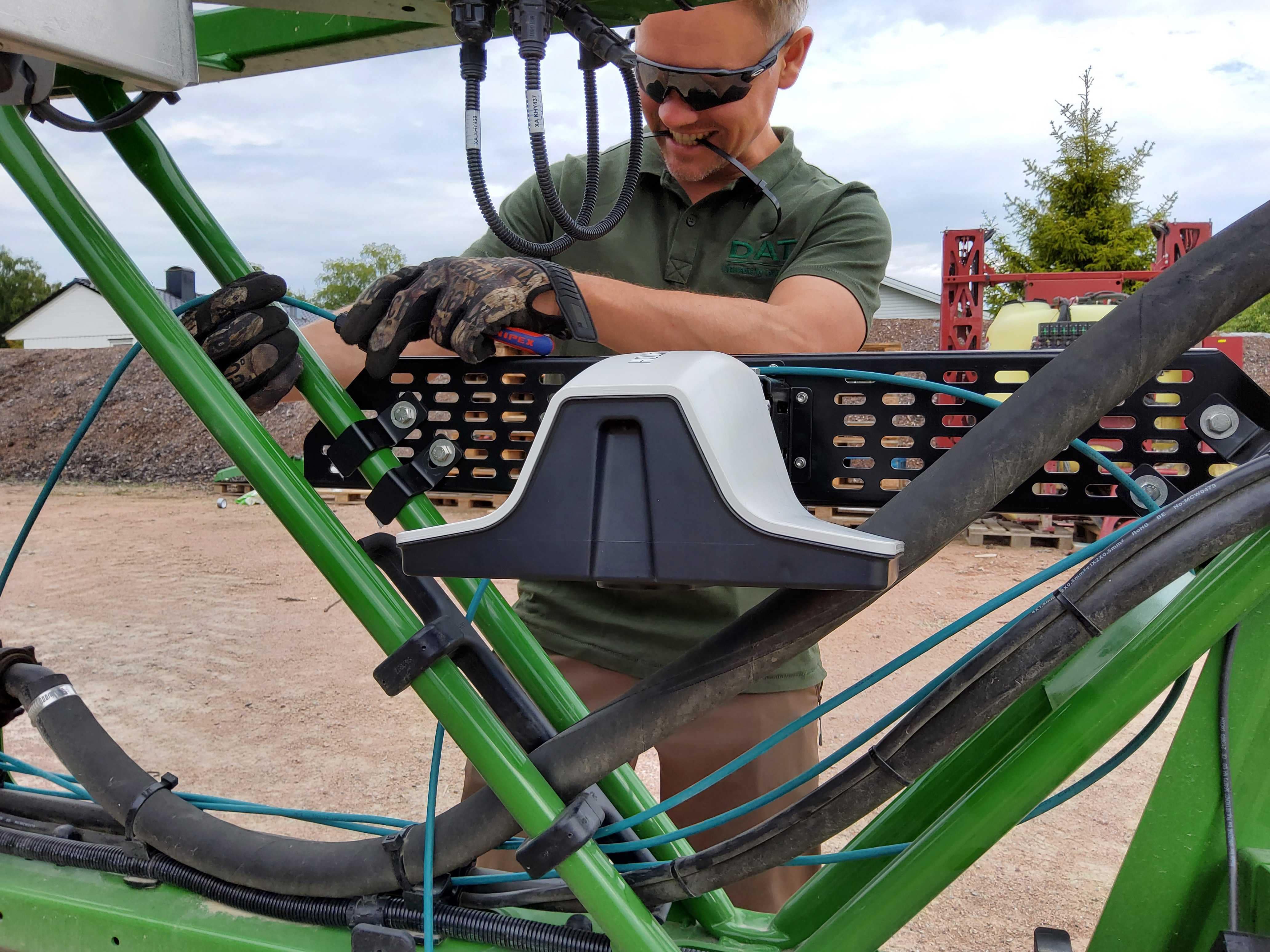 Inżynier z Dimensions Agri Technologies instaluje czujnik IoT wyposażony w sztuczną inteligencję, łączność w chmurze i karty SIM Com4 IoT w celu zwalczania wzrostu chwastów na polu.