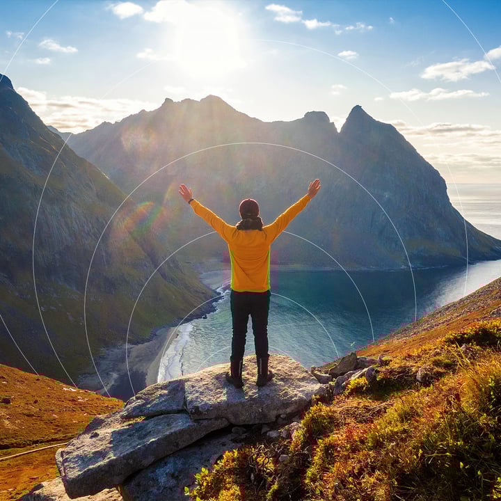 Engineer standing on a mountain peak celebrating best IoT connectivity provider 2026 with excellent global connectivity