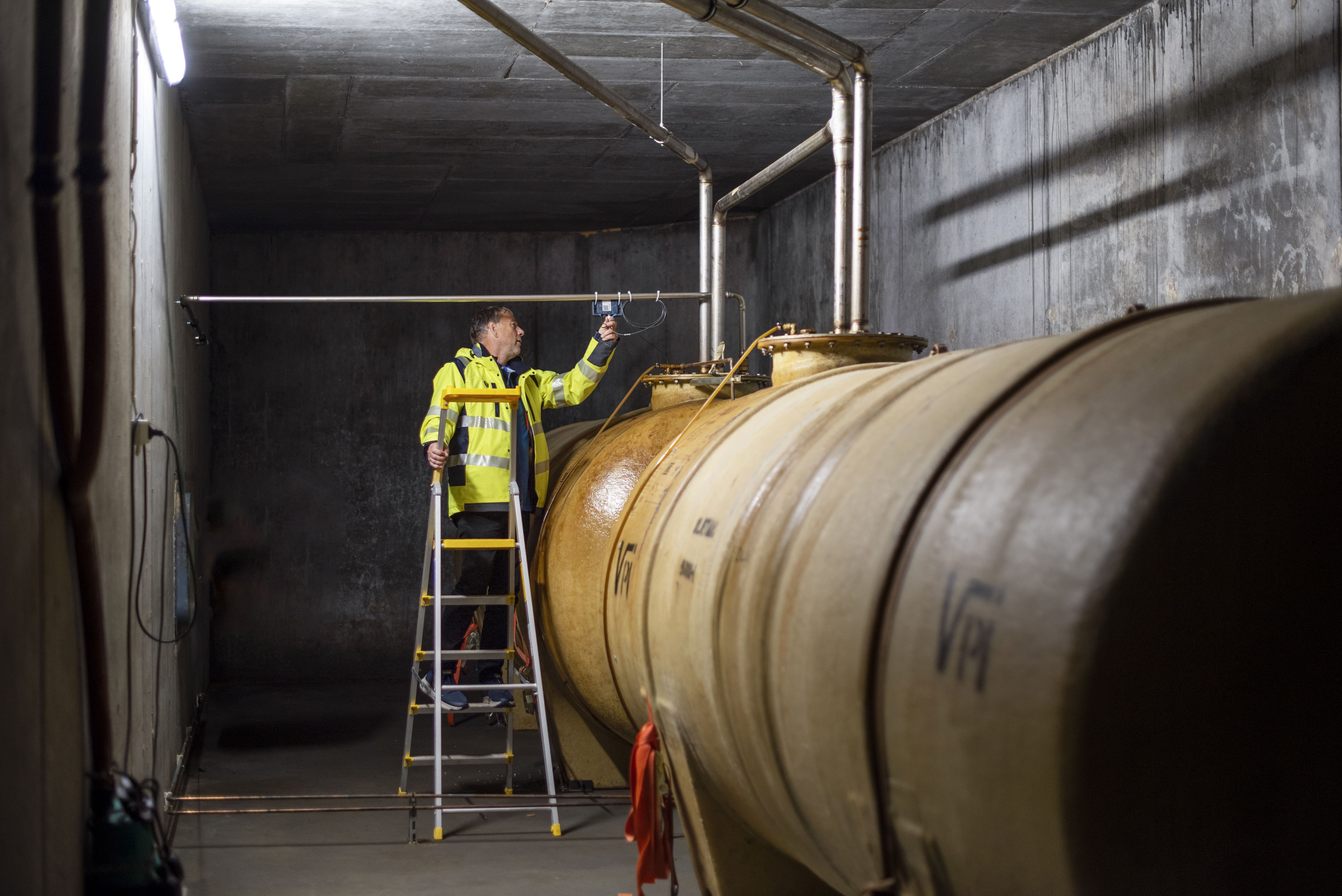 Engineer using a digital interface to monitor and control a tank connected to a Soolo IoT sensor for real-time data tracking