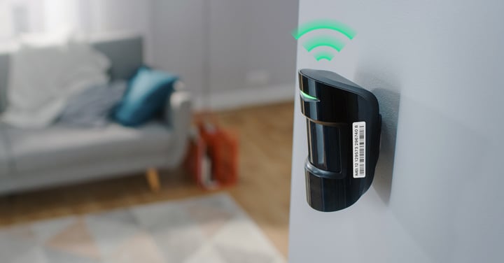 Un piccolo sensore domestico nero con bordi arrotondati. Il numero IMEI è chiaramente visibile sul retro, stampato in nero su un'etichetta bianca.