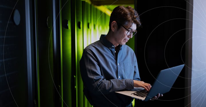 Professional working on a laptop in a secure data center
