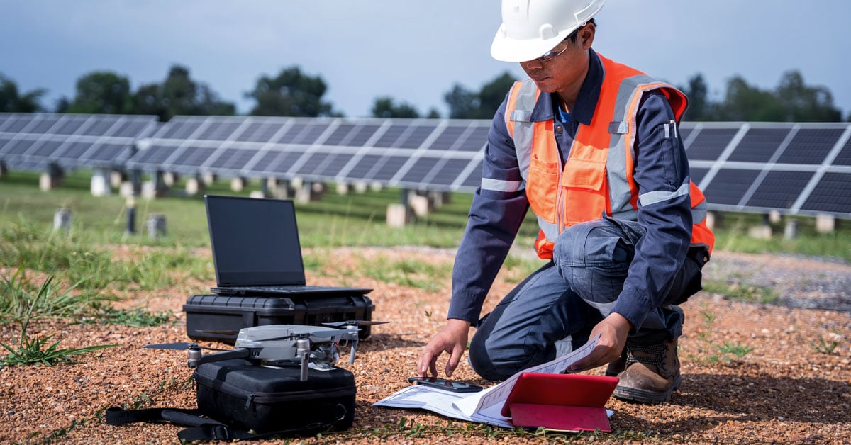 Engineer in a solar panel field operating a drone powered by cellular IoT connectivity.