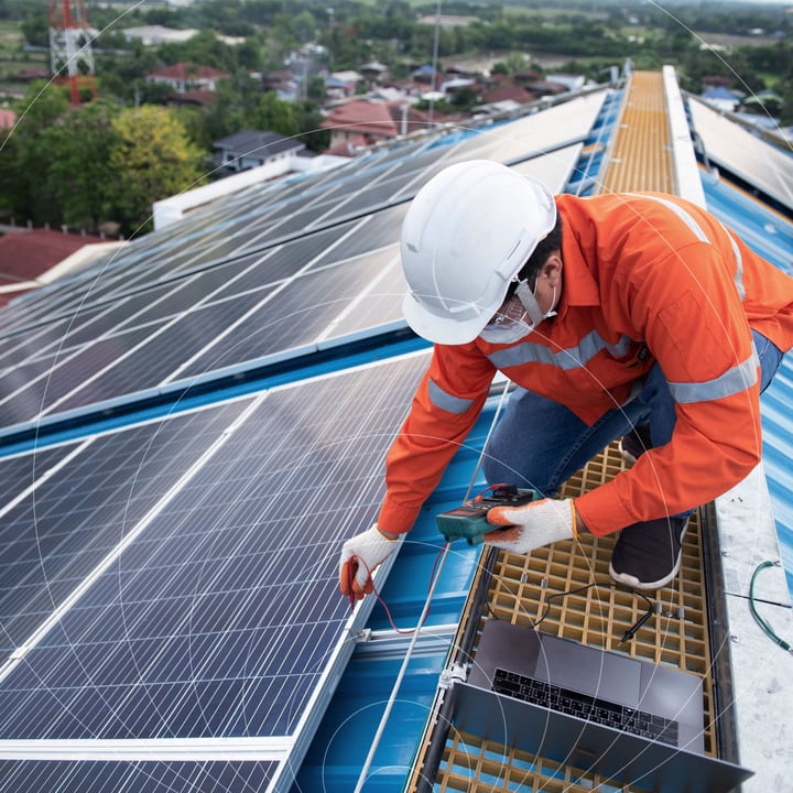 Engineer inspecting solar panels connected to IoT monitoring system, representing Com4’s smart connectivity solutions for energy infrastructure.