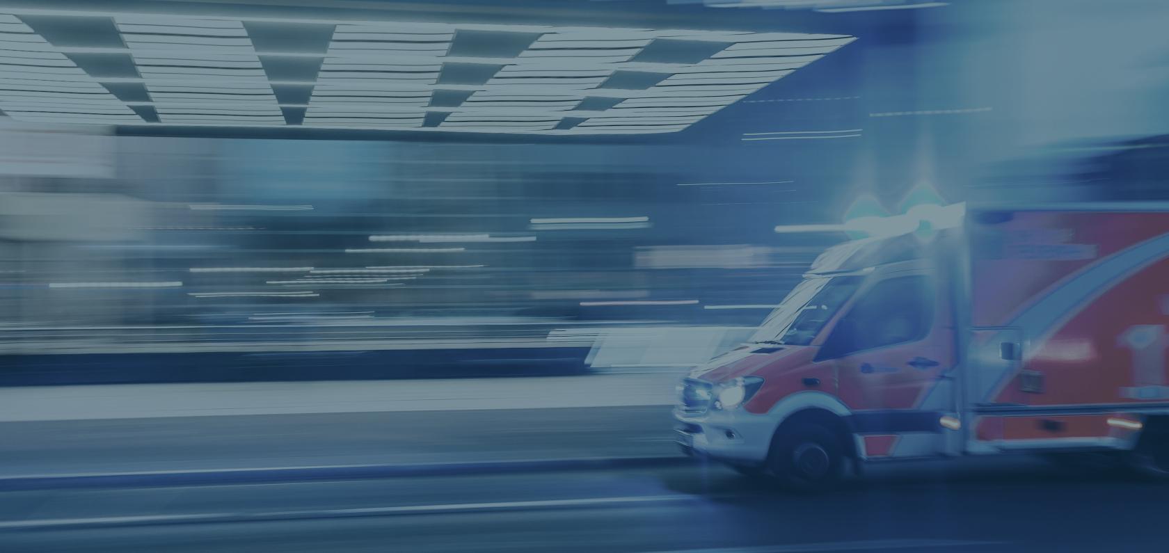 Ambulance parked at a hospital entrance, representing connected healthcare
