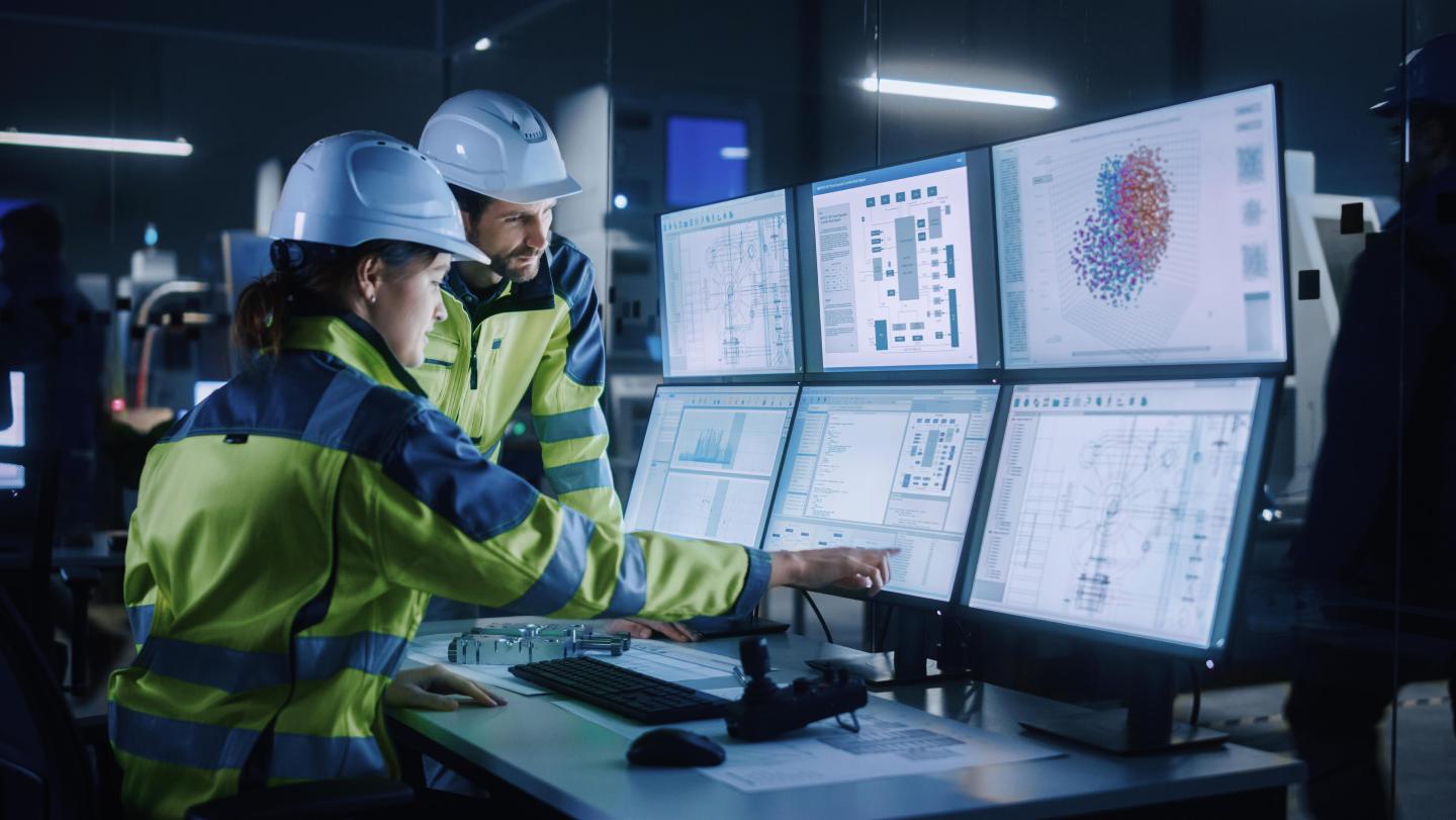 Industry workers infront of screens