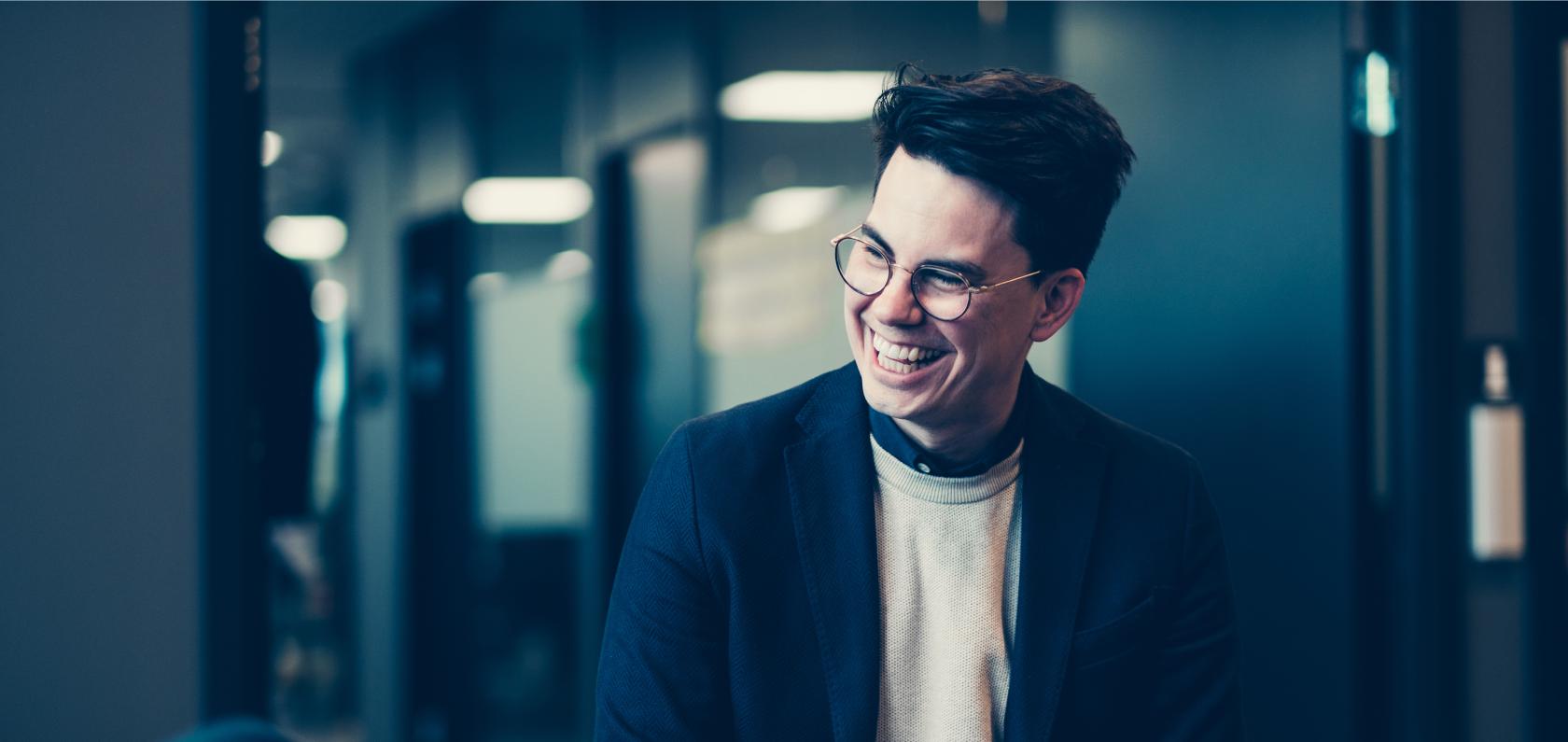 Com4 team member smiling in the office representing the people behind IoT connectivity