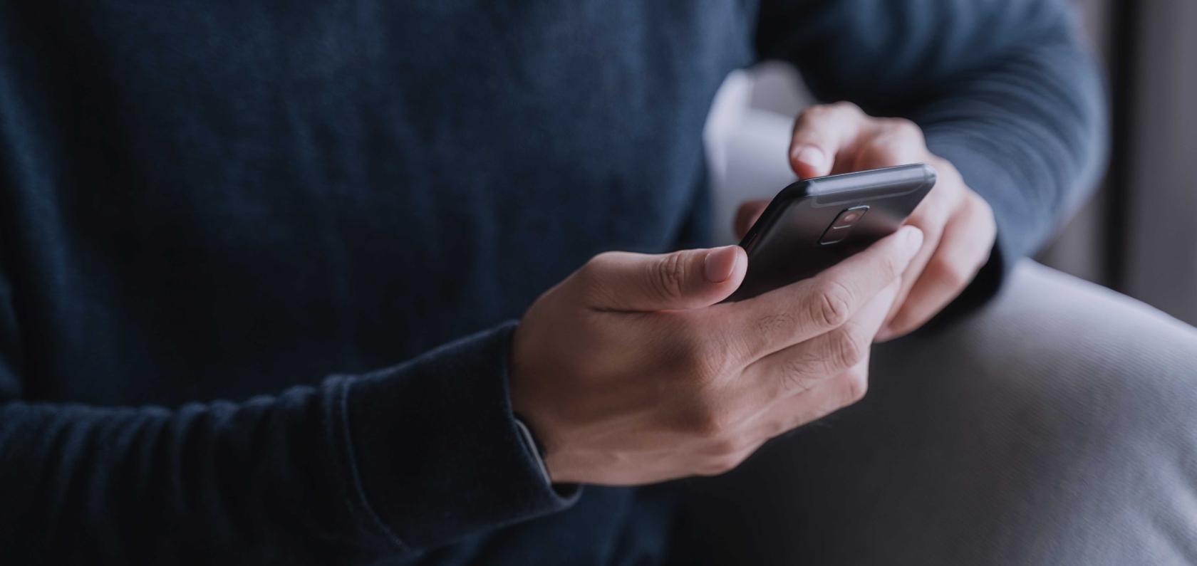 Person using a connected mobile device representing iSIM technology in modern smartphones