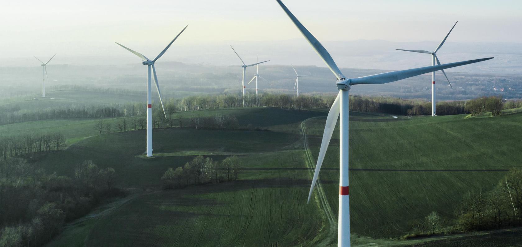 Wind turbines under a bright sky representing sustainable energy and environmental responsibility