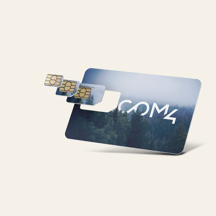 Com4 SIM card triple-cut punch-out card featuring a misty forest photo and the Com4 logo, with Mini, Micro, and Nano SIM formats detached and fanned out beside it.